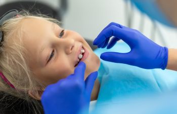 Little girl with dental braces during orthodontic checkup.