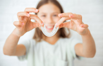 girl holding clear aligners, 