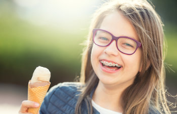 laughing girl with braces holds an ice cream, 
